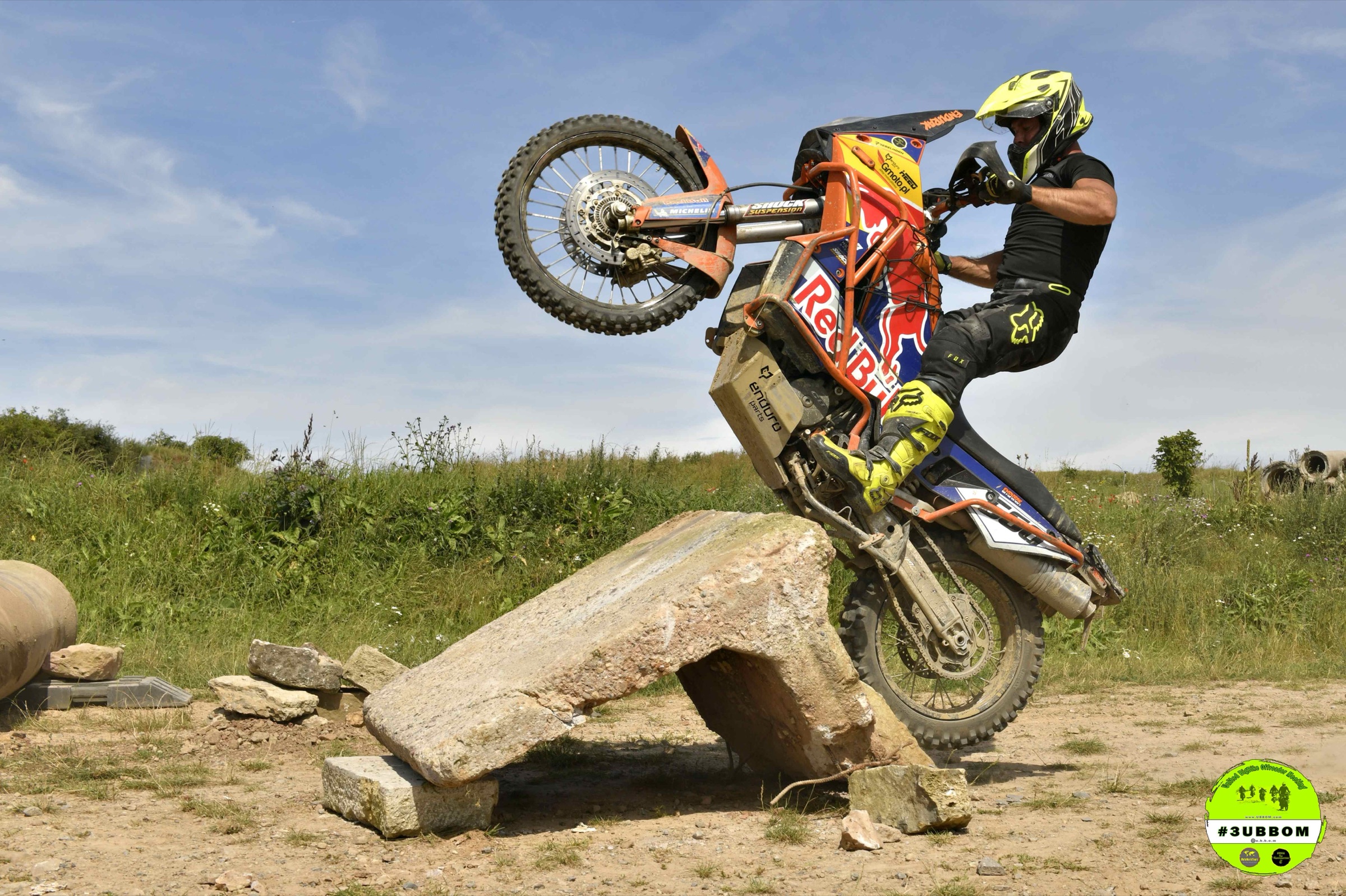 Fahrer stellt eine Reiseenduro auf das Hinterrad an einem Felsbrocken