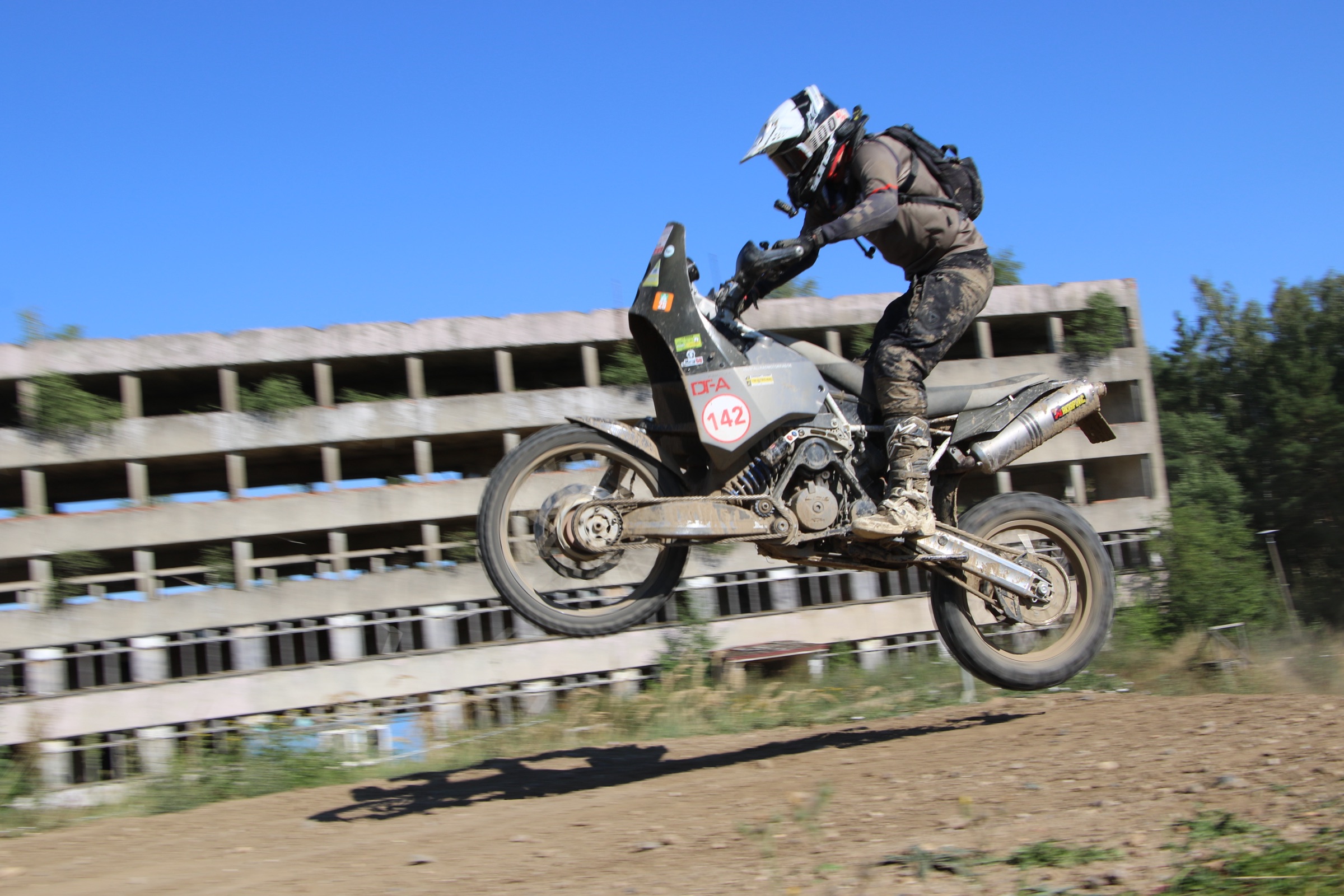 Sprung mit einer großen Enduro vor einem alten Gebäude